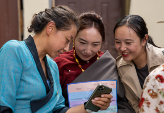 才永吉（左）向当地妇女展示如何使用智能手机在线学习健康知识。©联合国人口基金驻华代表处/王梓琪